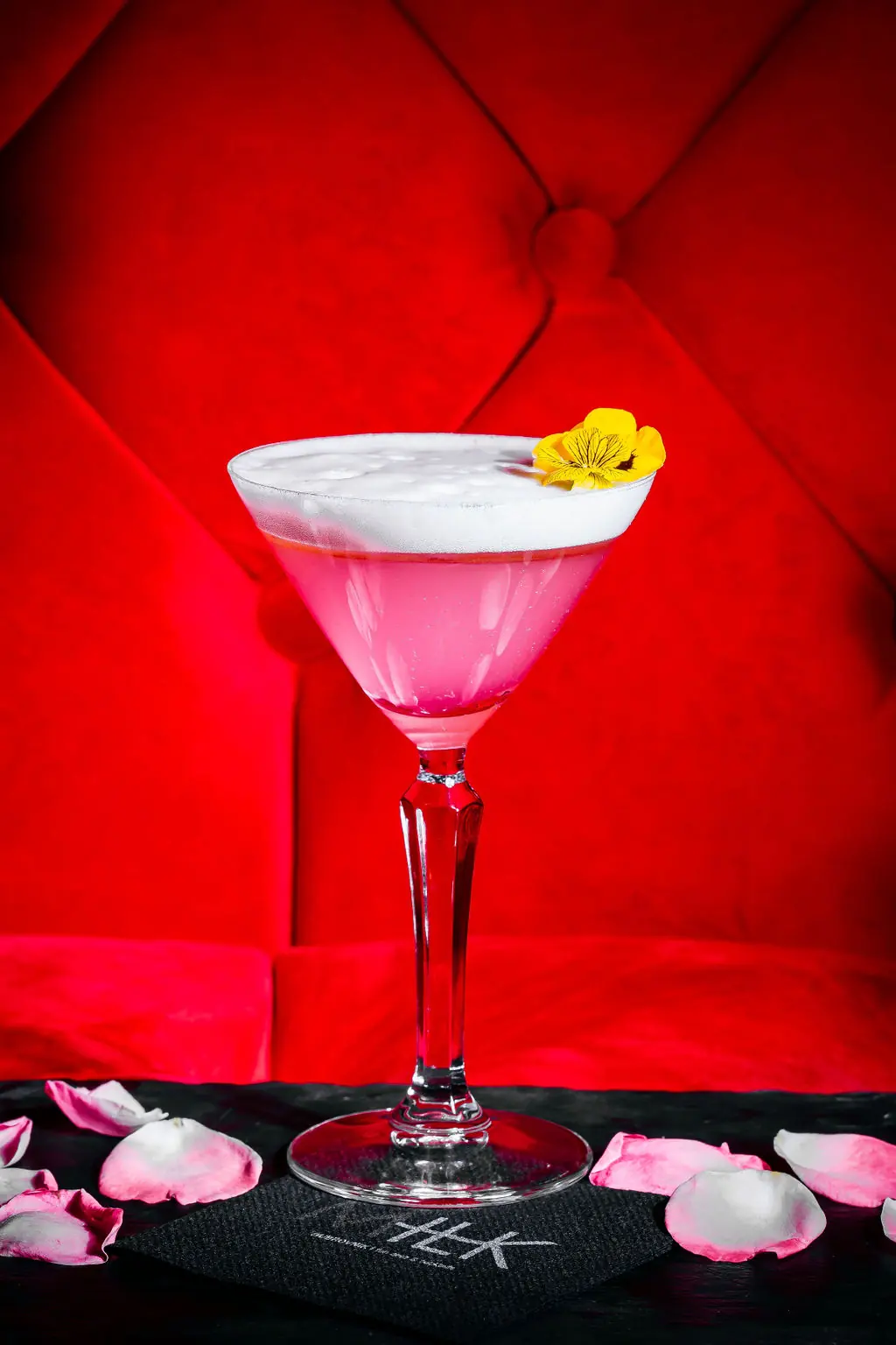 Pink cocktail on red velvet seating at MILK Dubrovnik gay bar