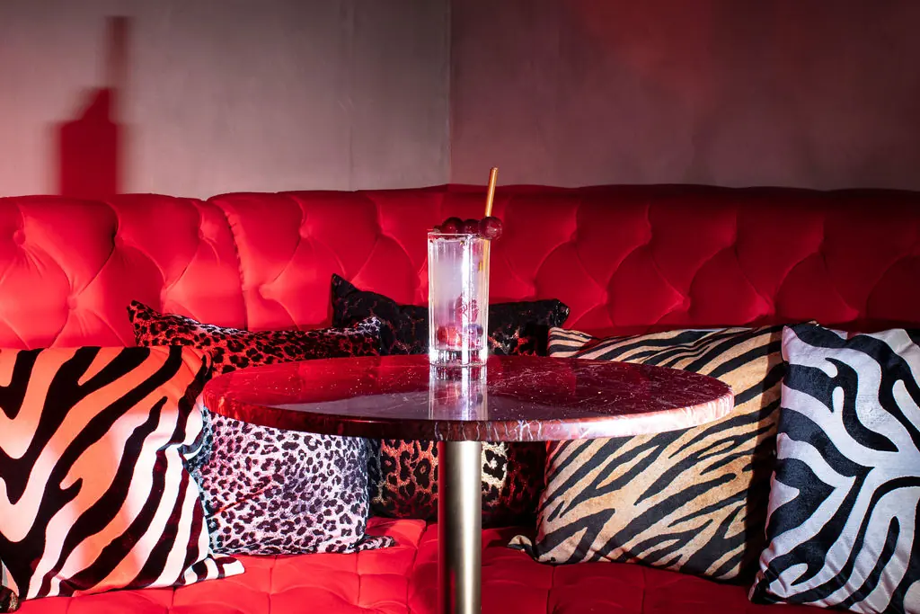 Red velvet sofa with zebra and leopard cushions at MILK nightclub Dubrovnik